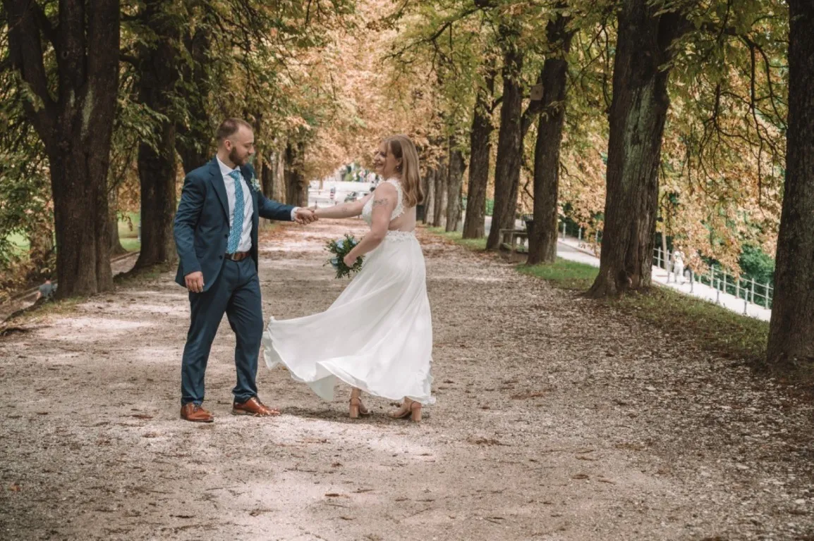Poročna fotografija mladoporočencev; ujet pristen trenutek z naravno svetlobo in umirjeno kompozicijo v dokumentarnem slogu.
